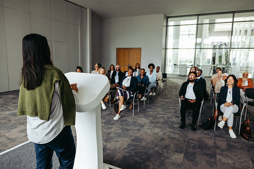 Female business leader speaking at a conference with an engaged audience