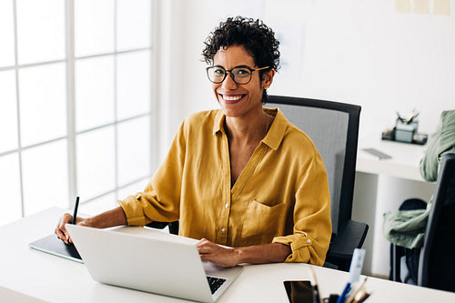 Female graphic designer working at her desk in an office