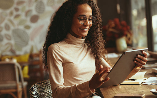 Woman using her digital tablet at cafe