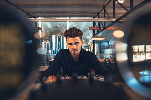 Brewer tasting varieties of craft beers at brewery