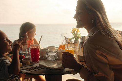 Family breakfast in a sunny overwater villa by the ocean