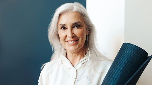Yoga essentials: Woman with yoga mat and earphones, ready for her next practice