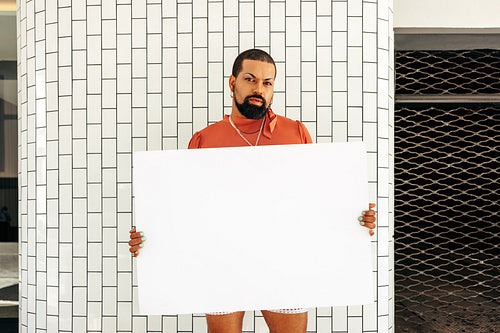 LGBTQ+ activist holding up a blank placard