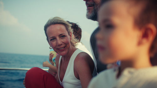 Excited family on a boat trip watching dolphins in the clear blue ocean