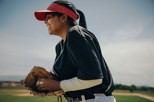 Passionate baseball pitcher prepares for a throw under a sunny sky