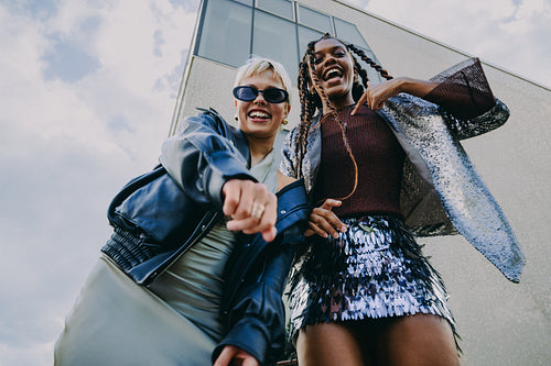 Fun friendship portrait of young women posing in the city
