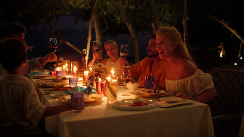 Family and friends enjoying a beautiful candlelit dinner at an island resort