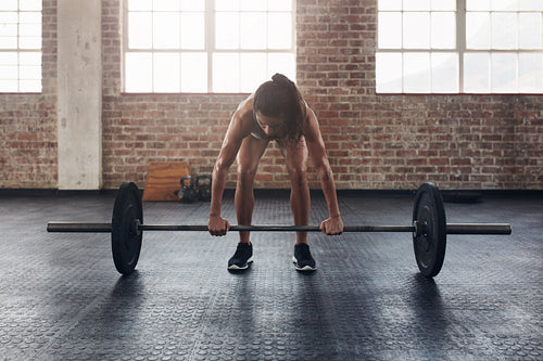 Fit young woman working out with a barbell