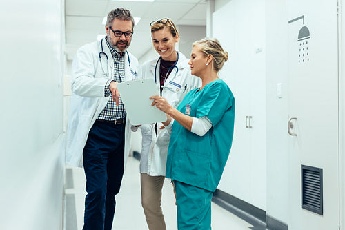 Team of doctors working on patients file at hospital