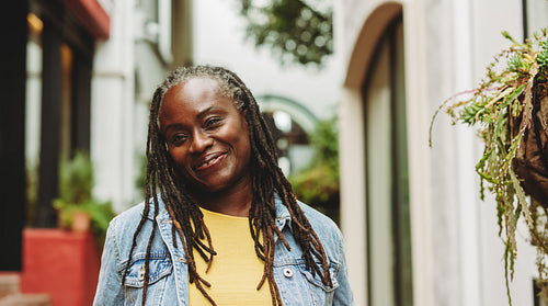 Happy woman with dreadlocks standing outdoors
