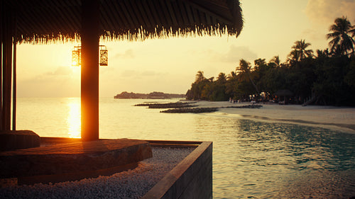 Chef preparing delicious teppanyaki meal for couple during romantic sunset dinner at oceanfront resort restaurant