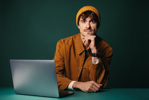 Creative work begins with a man using a laptop in the studio