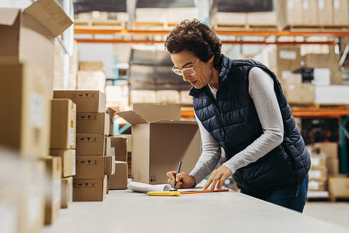 Warehouse manager writing a shipping list