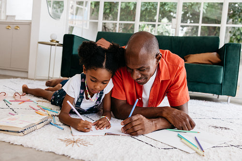 Father and daughter drawing together in a cozy living room