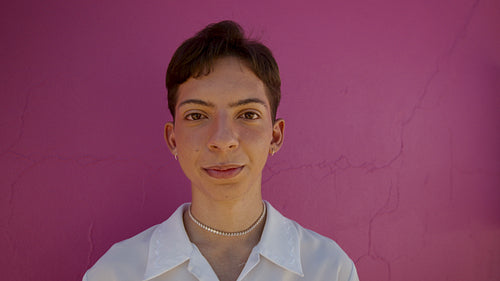 Gender queer standing against pink background