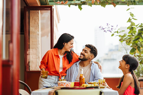 Happy family enjoying quality time together on a balcony during lunch