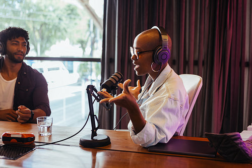 Podcast recording session with male and female hosts discussing topics in studio