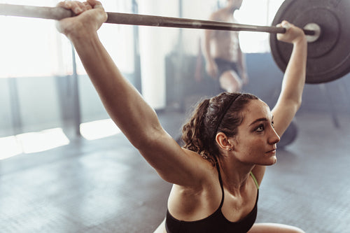 Female performing deadlift exercise with barbell