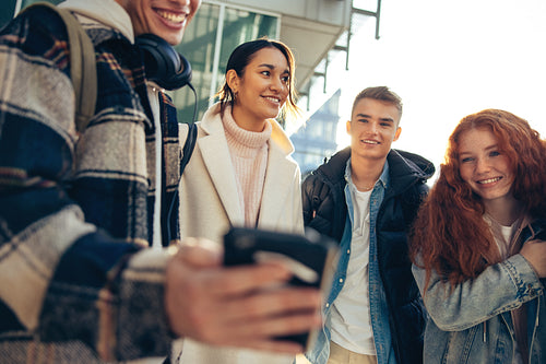 Students looking at cell phone and smiling
