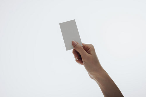 Hand holding a blank business card on a white background