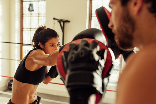 Beautiful young female pugilist throws a punch