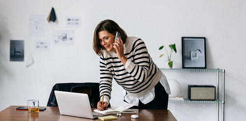Phone calls keep the woman multitasking at her office desk