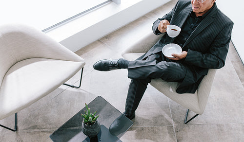 Senior businessman having coffee break in office