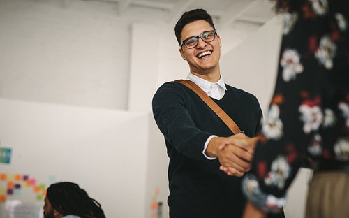 Smiling businessman greeting a business partner at work