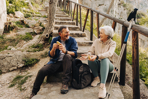 Cheerful senior couple having some bananas outdoors