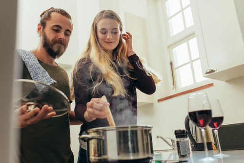 Happy couple cooking food together at home