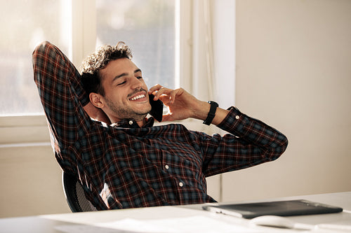Businessman talking over mobile phone in office