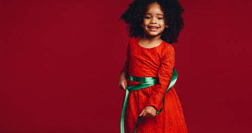 Little girl playing with a satin ribbon