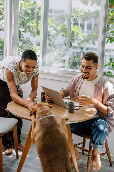 Happy couple enjoying time with their dog in a bright and cozy room