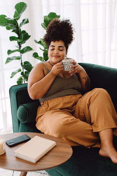 Female with coffee cup sitting on sofa