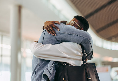 Couple meeting at airport arrival gate