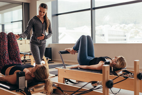 Pilates instructor training women at the gym