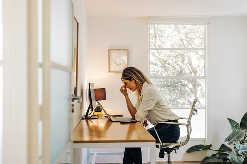 Exhausted businesswoman having a headache in her office