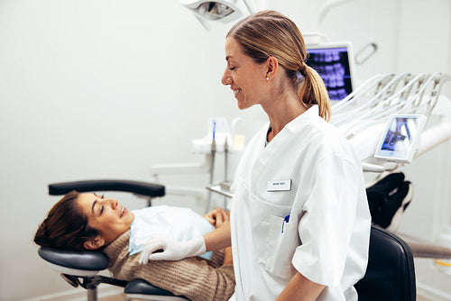 Dentist preparing female patient for treatment