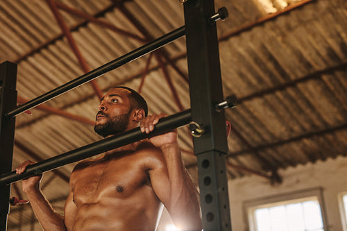 Muscular man doing pull up workout