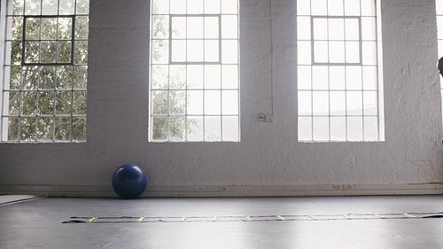Woman doing speed agility ladder drill exercises at fitness studio
