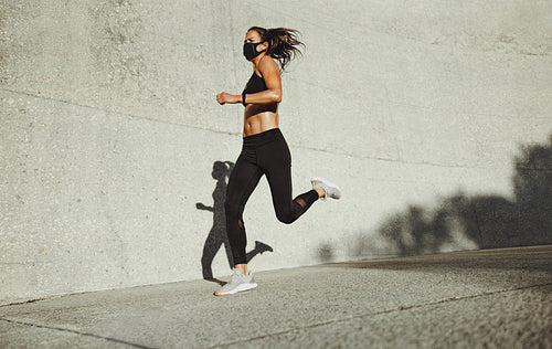 Sportswoman with face mask on morning run