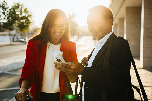 Business professionals enjoying a casual moment outdoors during a sunny day