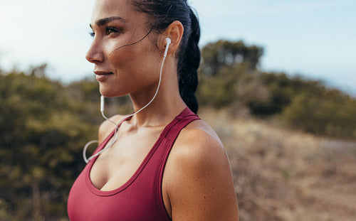 Athlete with earphones standing outdoors