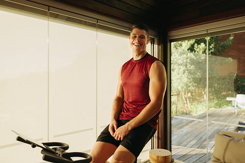 Happy young man getting into his workout routine with an exercise bike