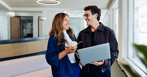 Business coworkers sharing ideas over laptop and coffee