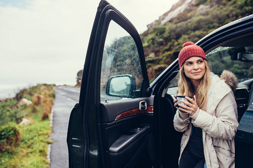 Woman having coffee during road trip