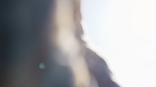 Girl looks at the sun through her hand