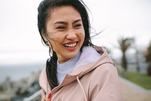 Close up of a smiling asian woman standing outdoors