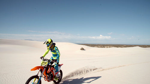 Motocross racer doing stunts on sand dunes