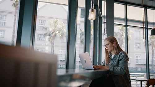 Woman sitting at coffee shop using laptop